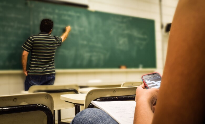 man in black and white polo shirt beside writing board