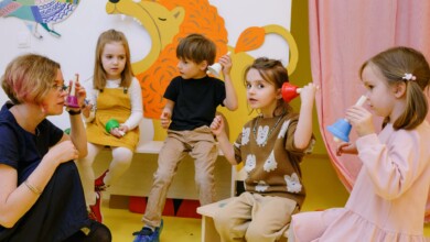 children with her students holding different color bells