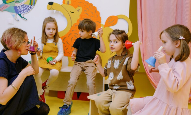 children with her students holding different color bells