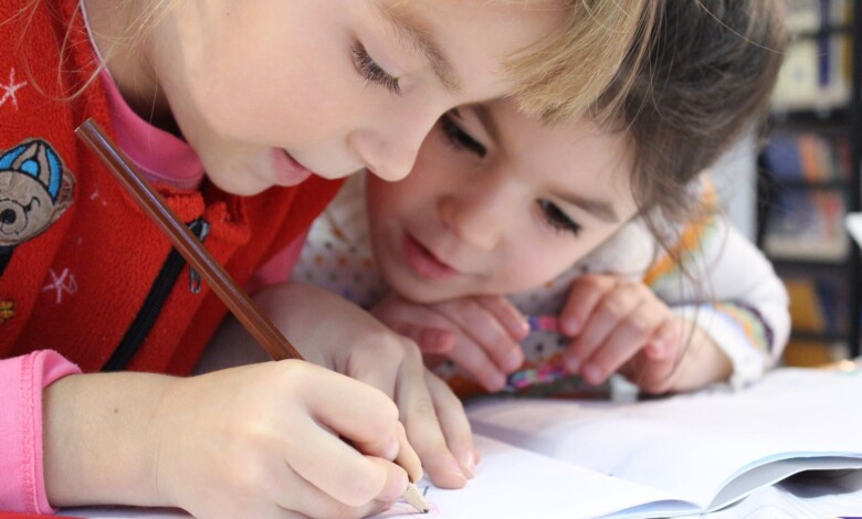 girls on desk looking at notebook