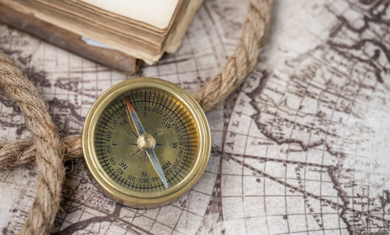gold compass and a rope on a map