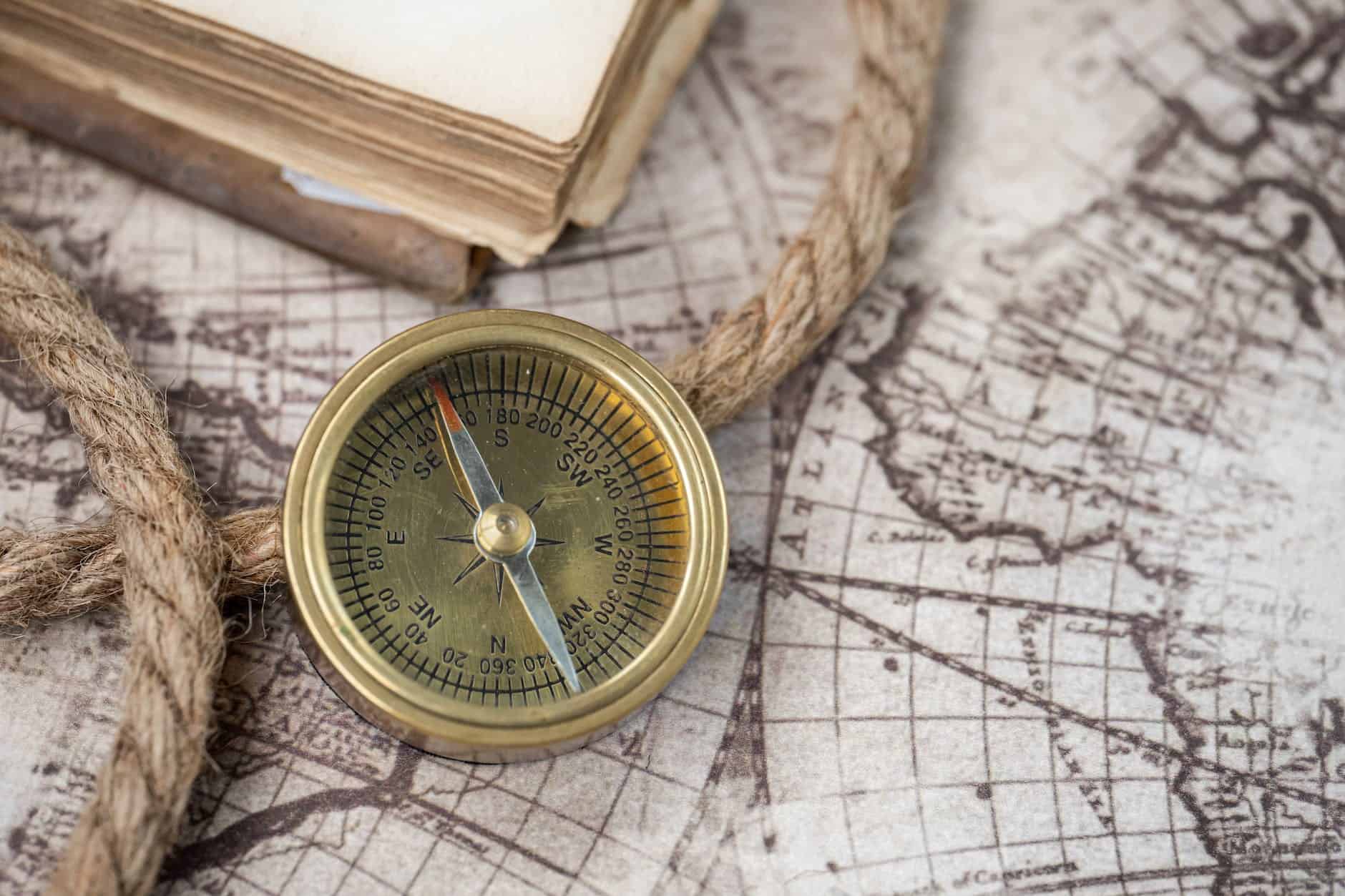gold compass and a rope on a map