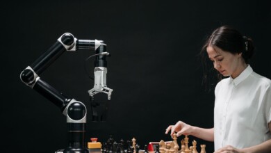 woman in white shirt playing chess against a robot