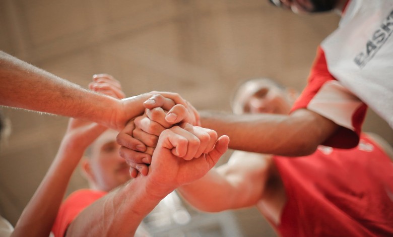 basketball team stacking hands together