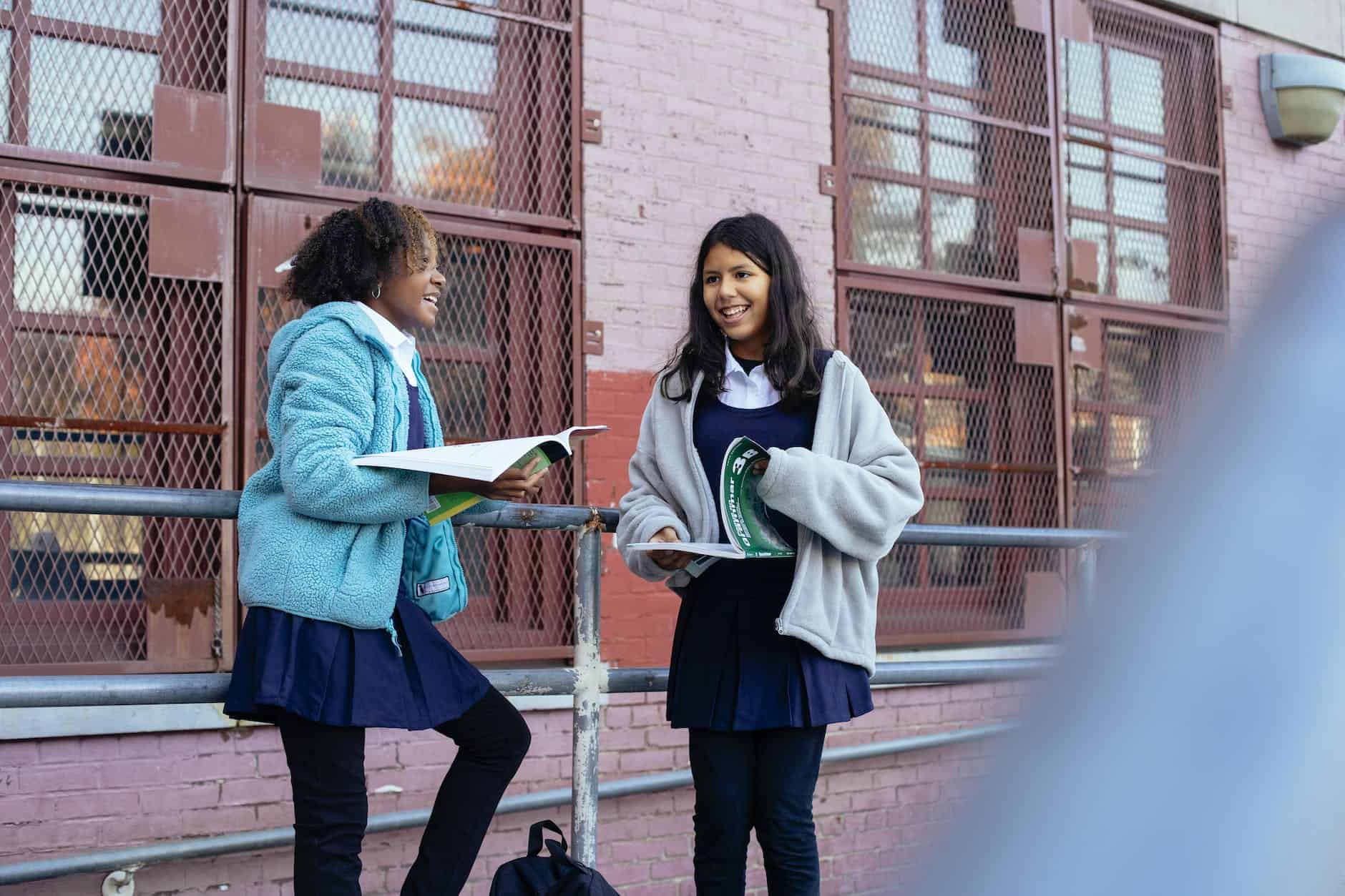 happy smiling diverse girls discussing lessons after school