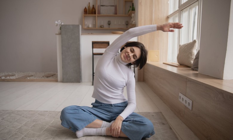 smiling woman practicing yoga with closed eyes at home