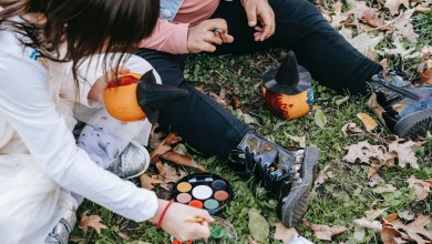 crop children painting pumpkins in autumn park