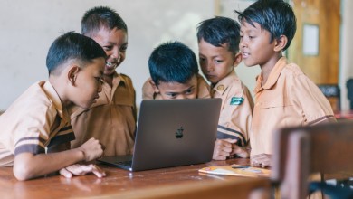 boy using silver macbook indoors