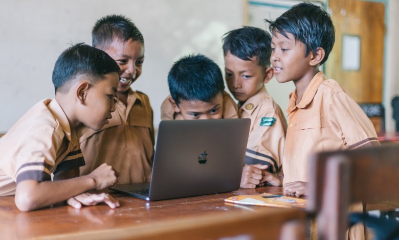 boy using silver macbook indoors