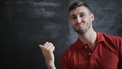 man in red polo shirt standing beside chalk board