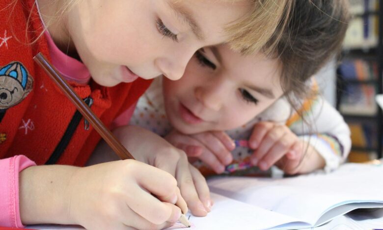 girls on desk looking at notebook