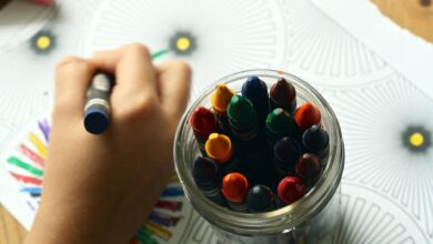 person coloring art with crayons