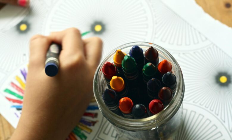 person coloring art with crayons