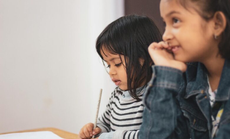 two girls writing on paper
