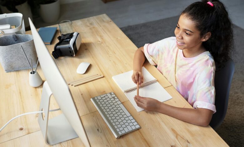 girl in pink t shirt looking at the imac
