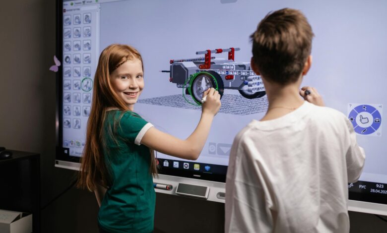 two kids standing by an interactive board
