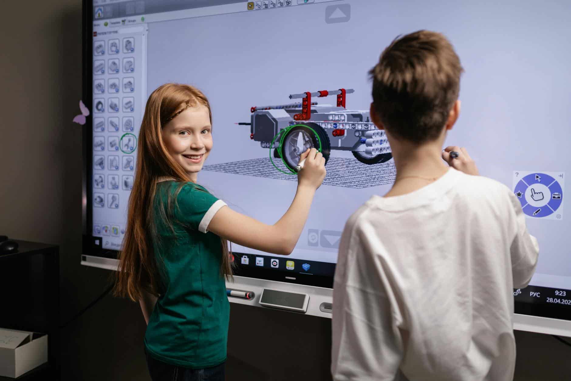 two kids standing by an interactive board