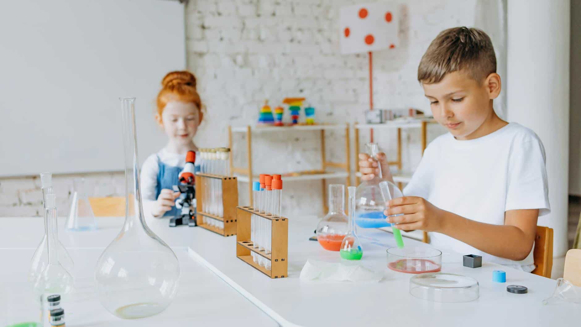 a boy and girl doing experiment in the laboratory