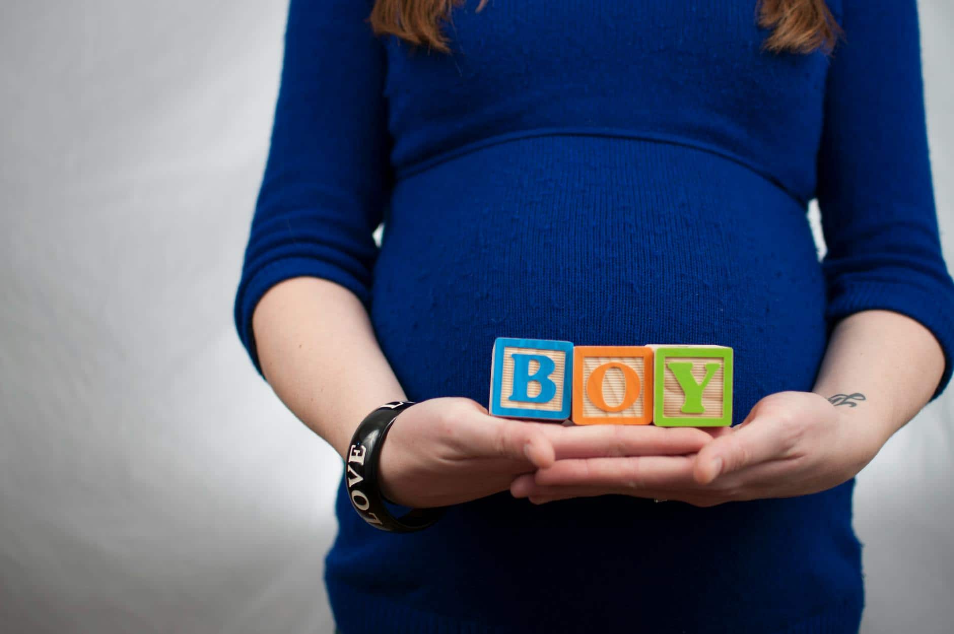 lady wearing lbue long sleeve dress and holding boy piece box