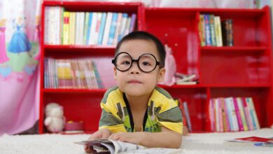 boy standing near bookshelf