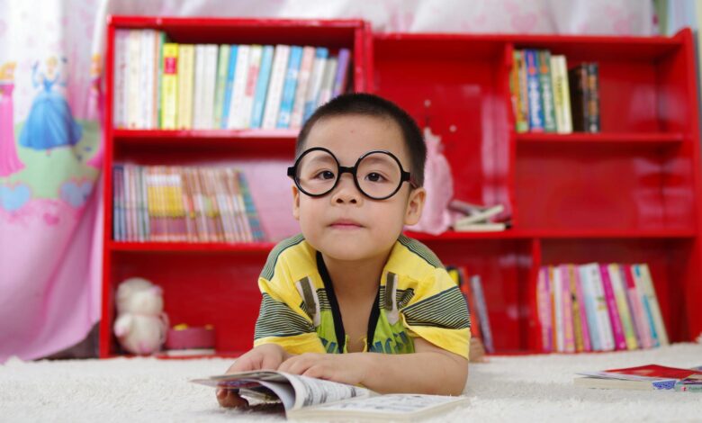 boy standing near bookshelf