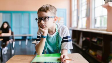 a boy wearing eyeglasses in the classroom