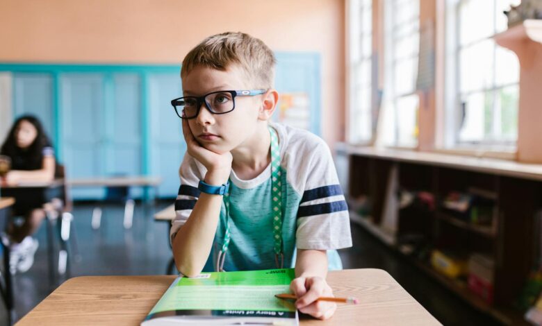 a boy wearing eyeglasses in the classroom