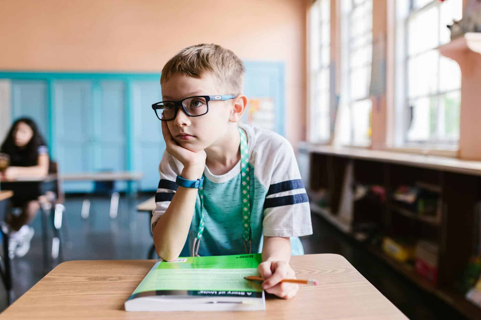 a boy wearing eyeglasses in the classroom