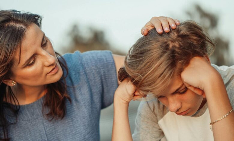 woman in blue shirt talking to a young man in white shirt