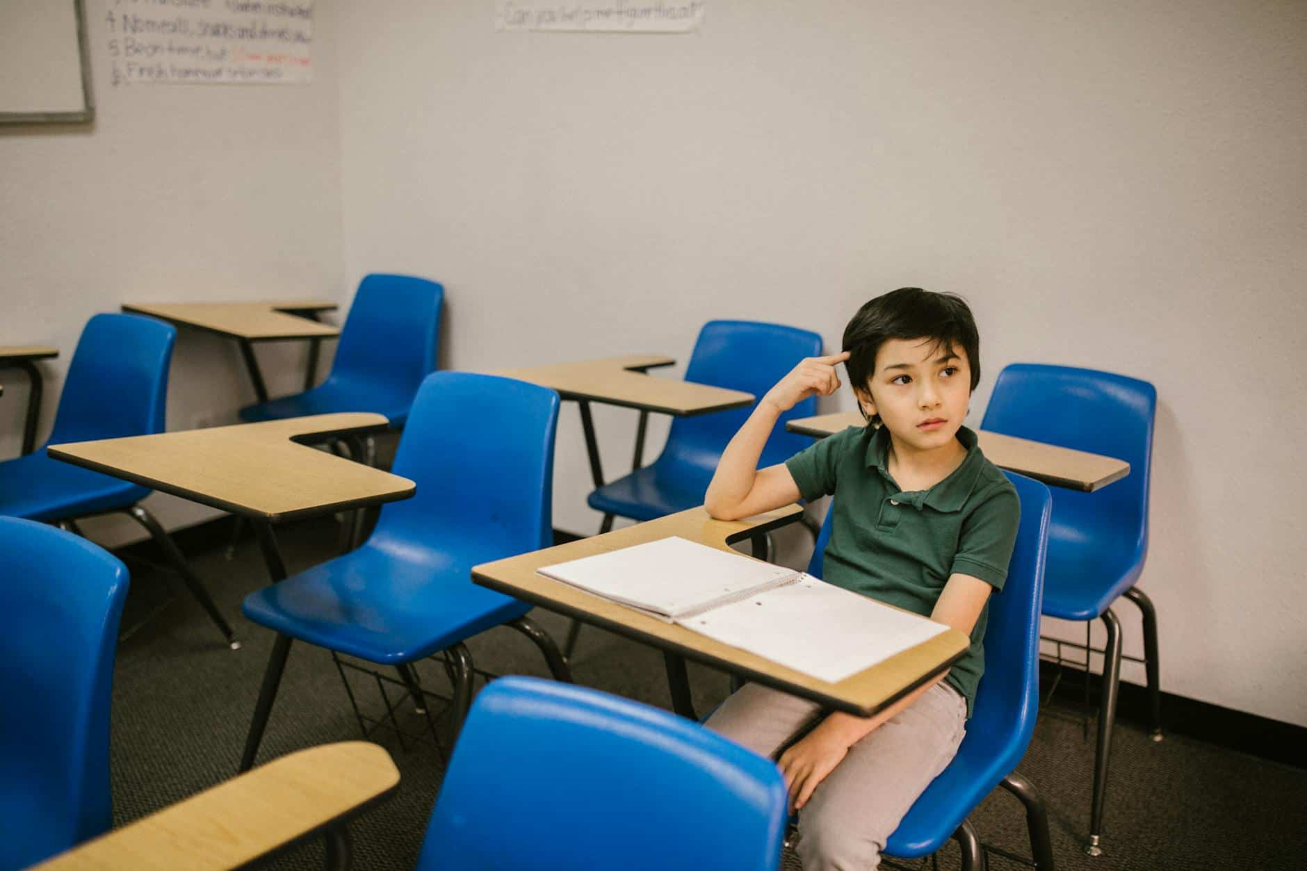 boy sitting on his desk looking lonely