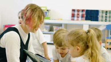 children in the school reading a book with a teacher
