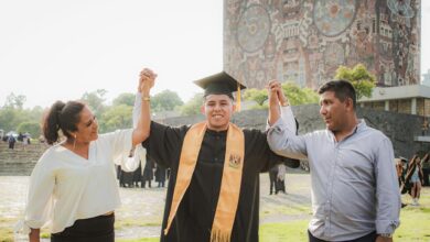 mother and father holding hands with graduate son