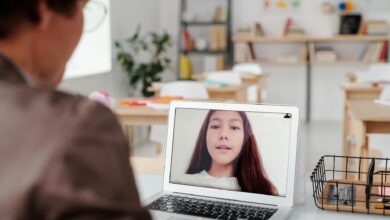 a teacher teaching a girl using laptop