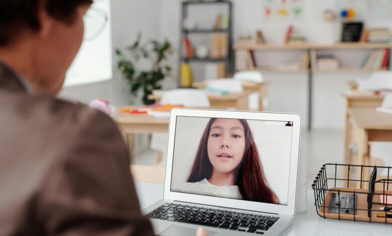 a teacher teaching a girl using laptop