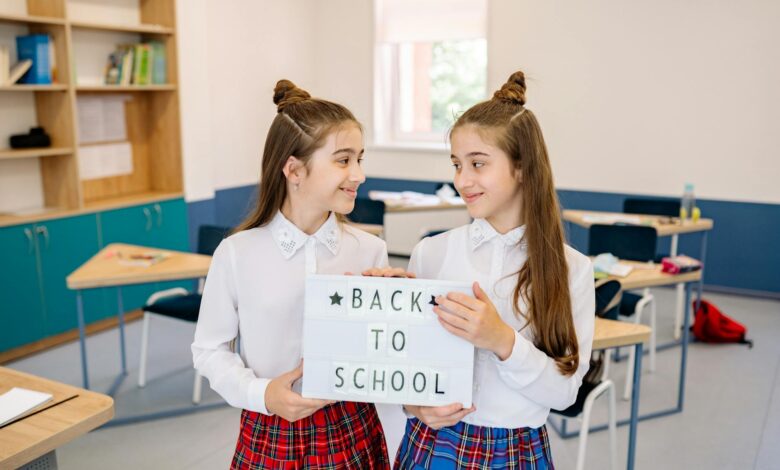 students holding a letter light box while looking at each other