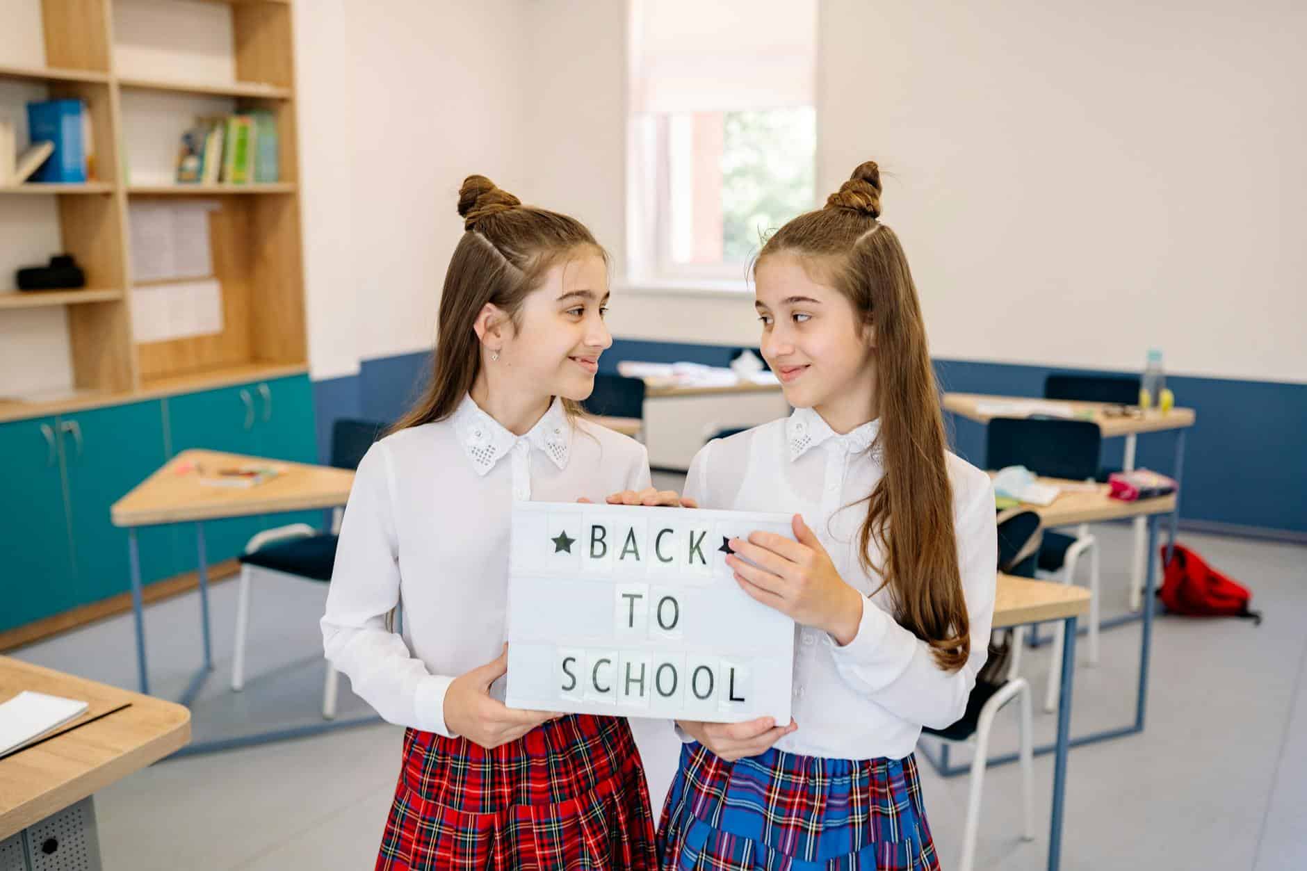 students holding a letter light box while looking at each other