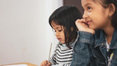 two girls writing on paper