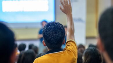 student raising hand in classroom setting