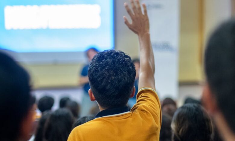 student raising hand in classroom setting