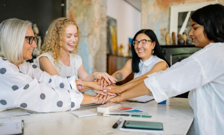 women putting their hands together