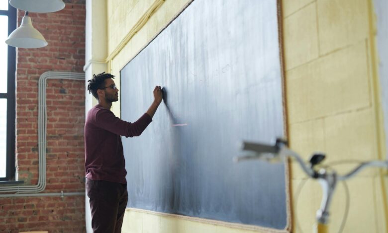man writing on a blackboard