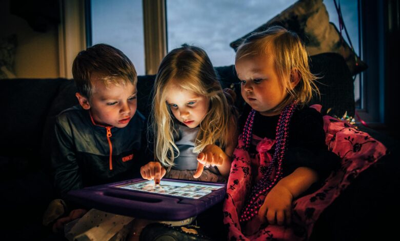 three children looking at a tablet computer
