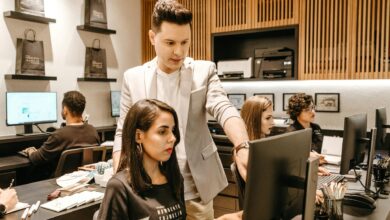 man teaching woman in front of monitor