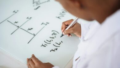 photo of person deriving formula on white board