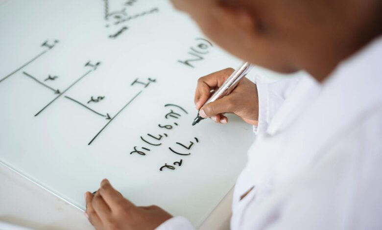 photo of person deriving formula on white board