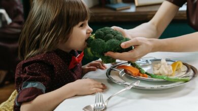 boy biting on a broccoli