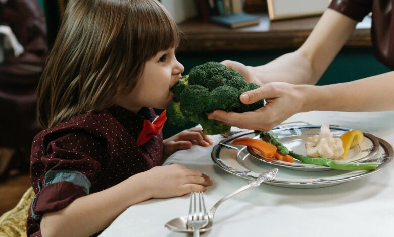 boy biting on a broccoli