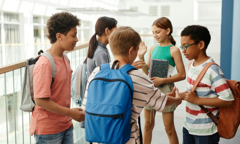 students standing on the hallway while having a conversation