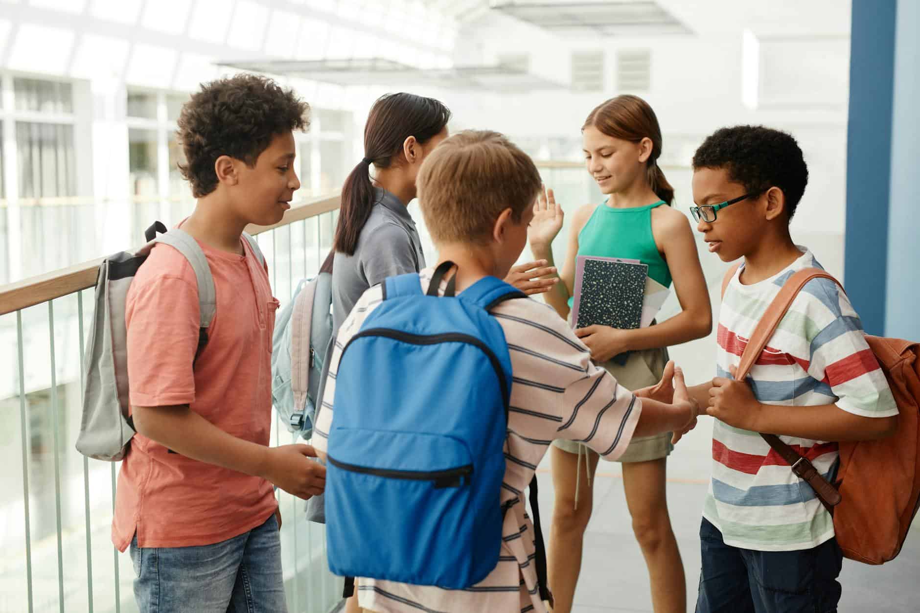 students standing on the hallway while having a conversation