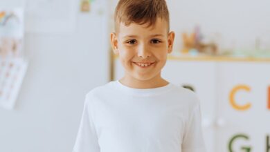 boy in white crew neck shirt holding a book